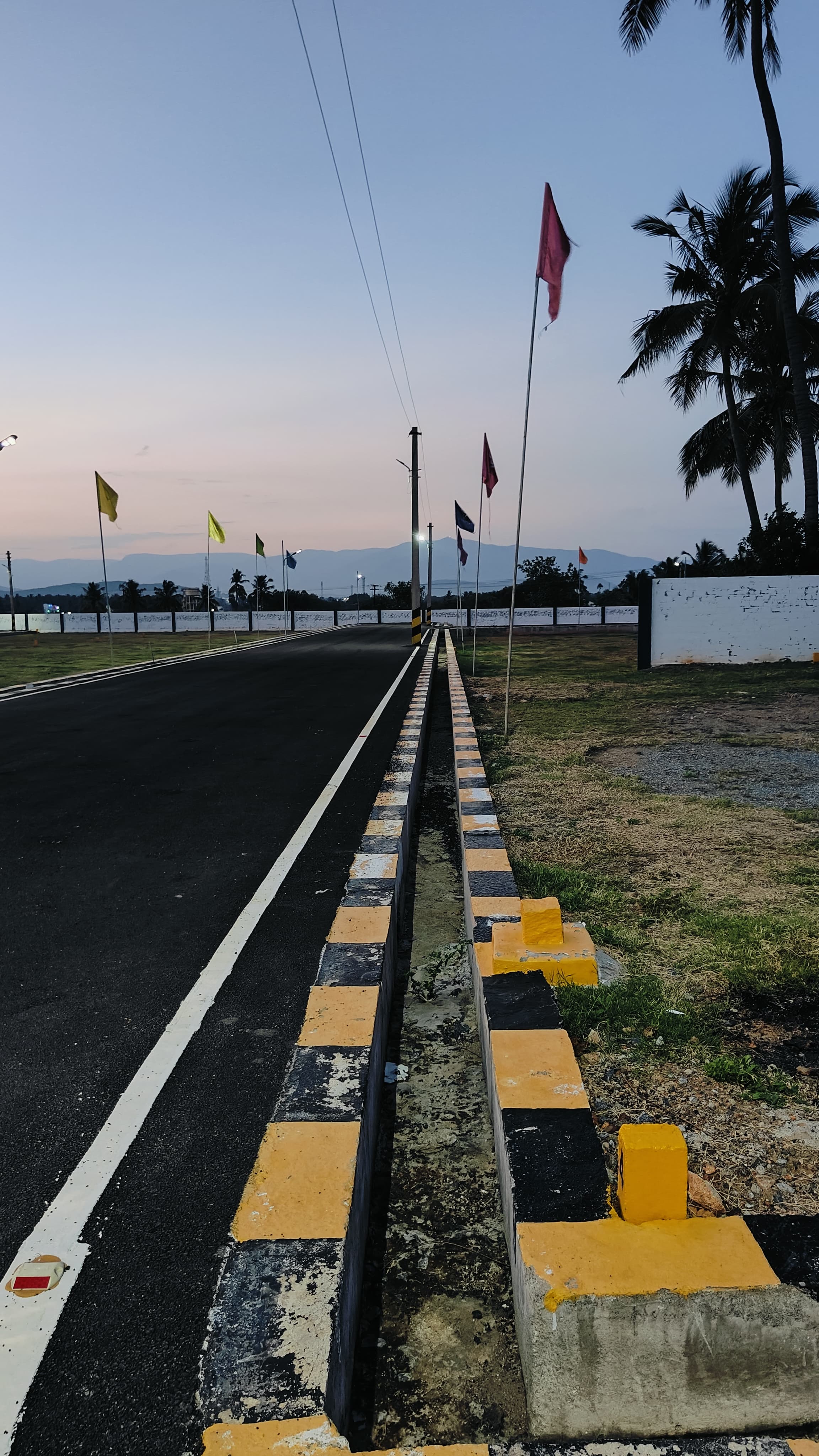 Tar road with kerbs and hills in the distance at the Valapadi layout