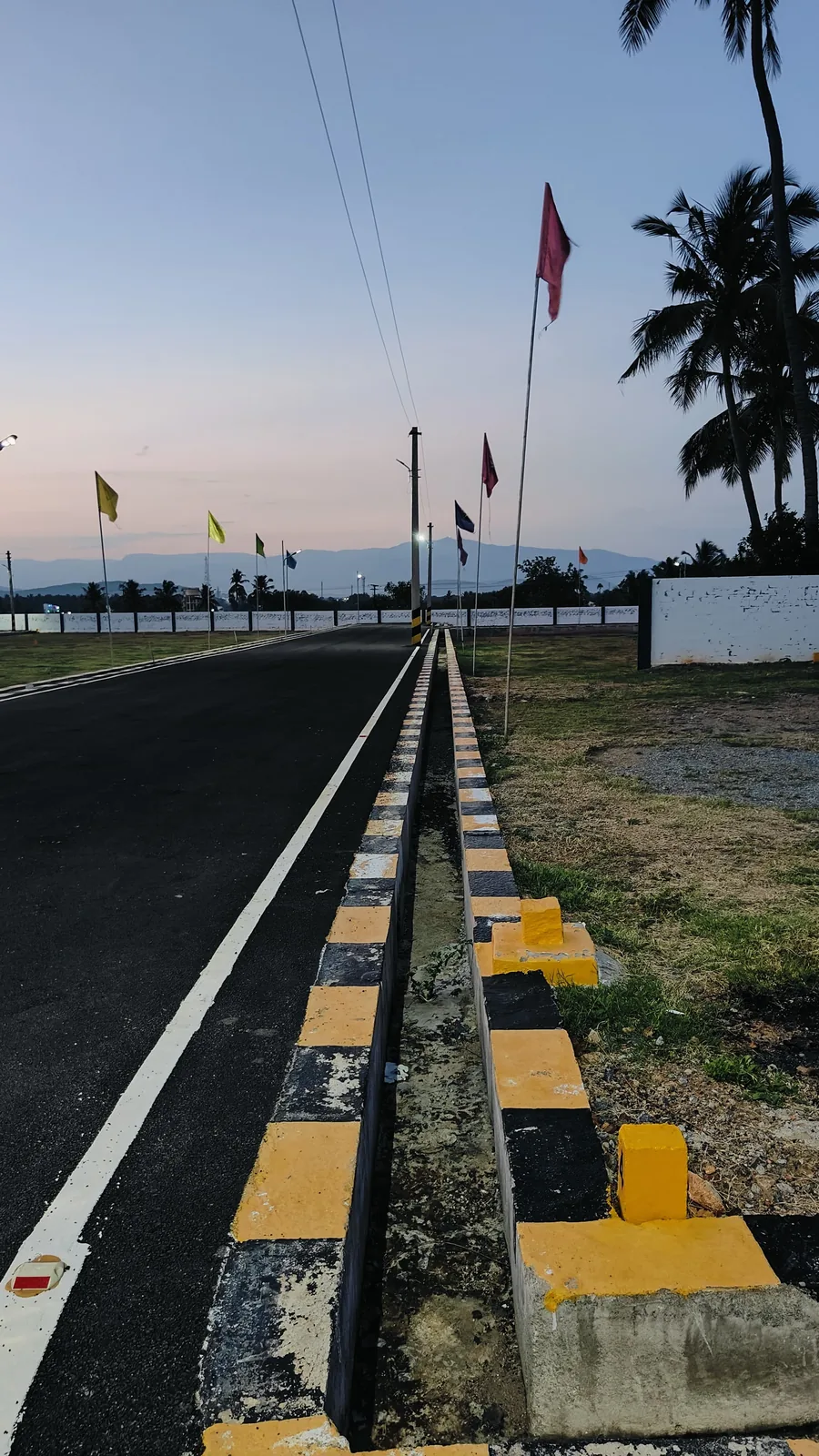 Tar road with kerbs and hills in the distance at the Valapadi layout